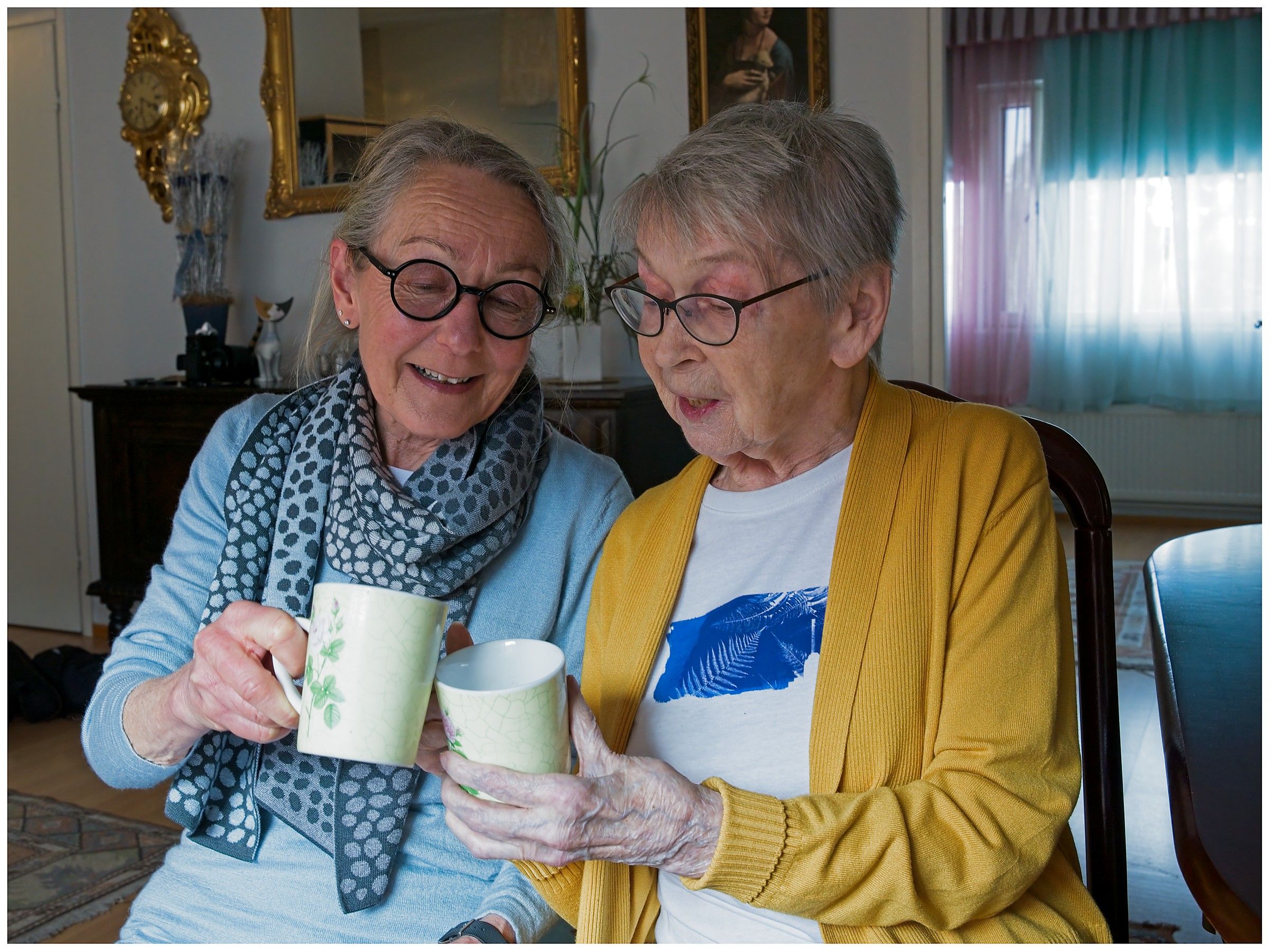Vapaaehtoinen ja asiakas juomassa kahvit yhdessä jutellen ja viihtyen
